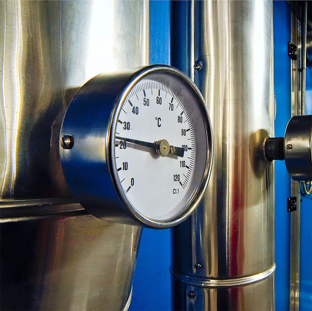 Celsius temperature gauge mounted on a stainless steel industrial process cooling tank reading approximately 20 degrees, demonstrating precise temperature monitoring in process cooling applications
